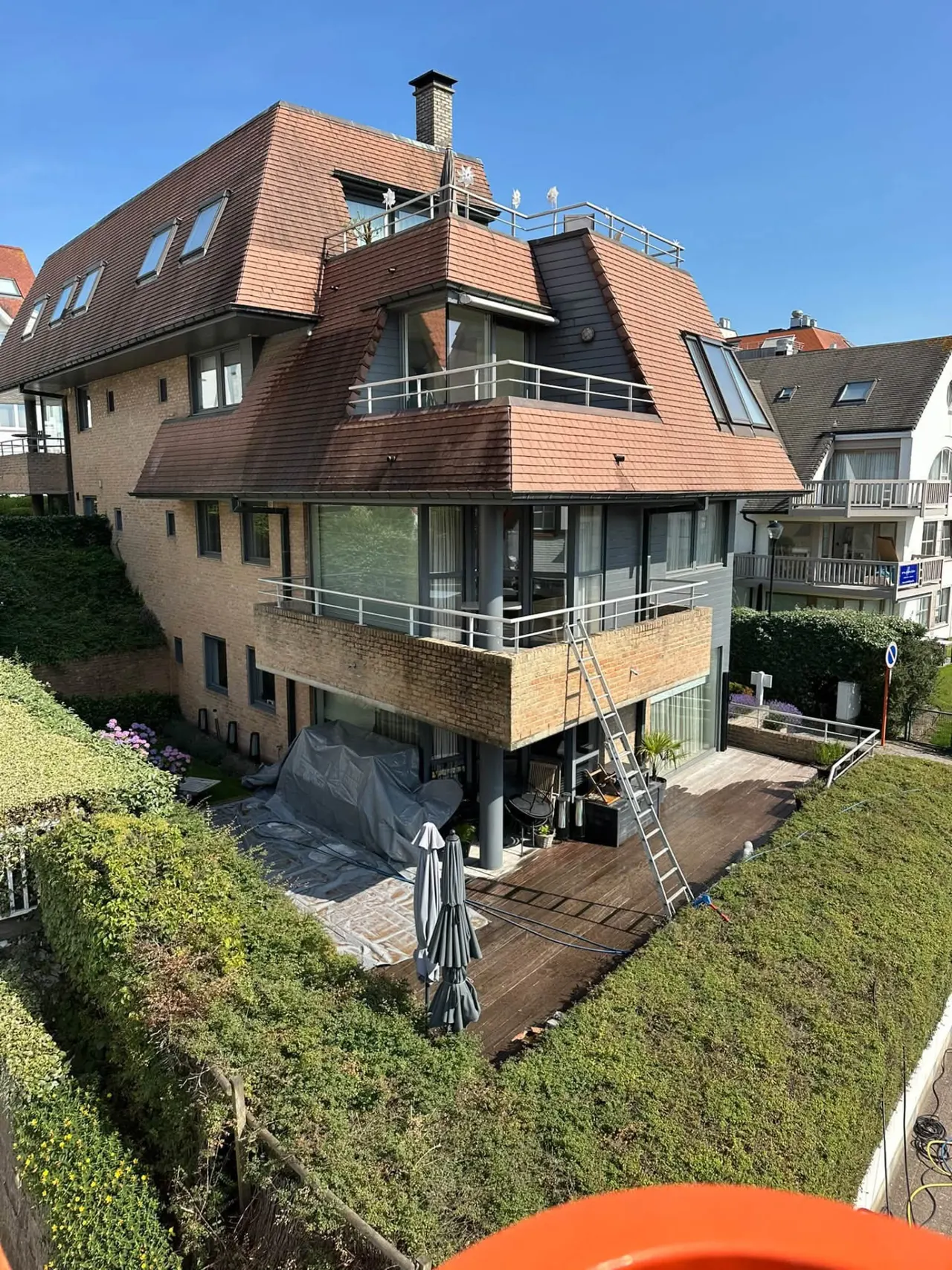 Dakreiniging bij een appartementsgebouw, uitgevoerd vanuit een hoogtewerker